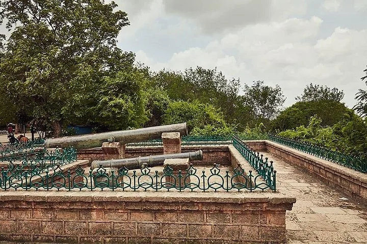 another view of old cannons on a raised platform with green railings