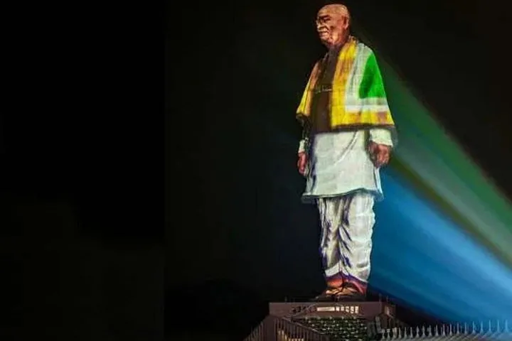 a light projection display on the Statue of Unity at night