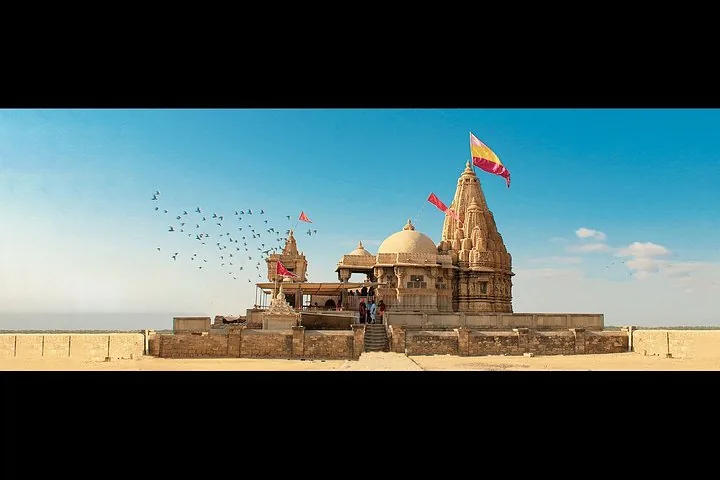a temple by the sea with flags flying and birds in the sky
